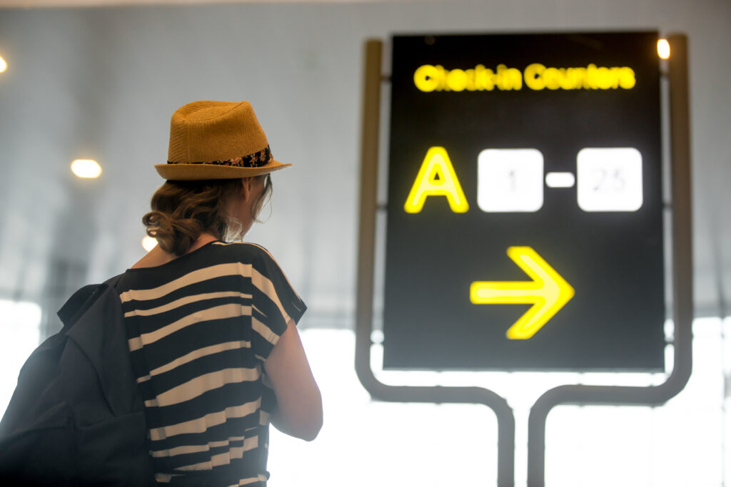 girl looking at airport information board girl looking at airport information board