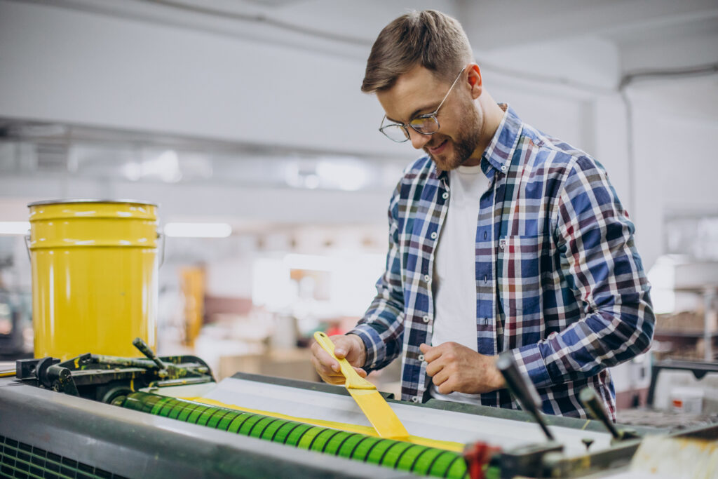 man working in printing house with paper and paints man working in printing house with paper and paints